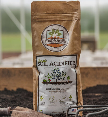 bag of soil acidifier with garden trowel in the garden soil